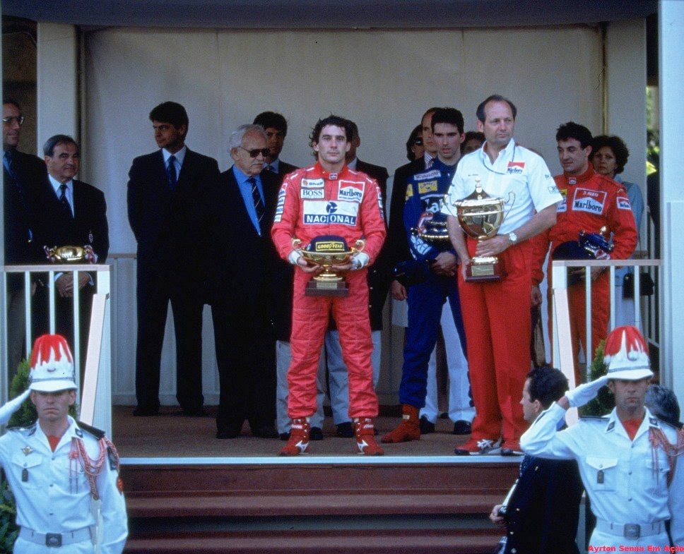 Pódio do GP de Mônaco de 1993 com Ayrton Senna em primeiro lugar, Damon Hill em segundo e Jean Alesi em terceiro, com Ron Dennis ao lado de Senna recebendo o troféu da McLaren