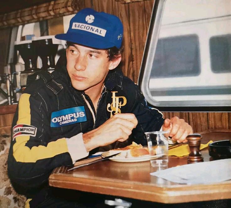 Ayrton Senna lanchando durante fim de semana de corrida, com o icônico macacão preto e dourado da Lotus no ano de 1986