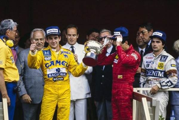 Ayrton Senna após sua primeira vitória no GP de Mônaco em 1987, no pódio ao lado de Nelson Piquet e Michele Alboreto durante a cerimônia de premiação