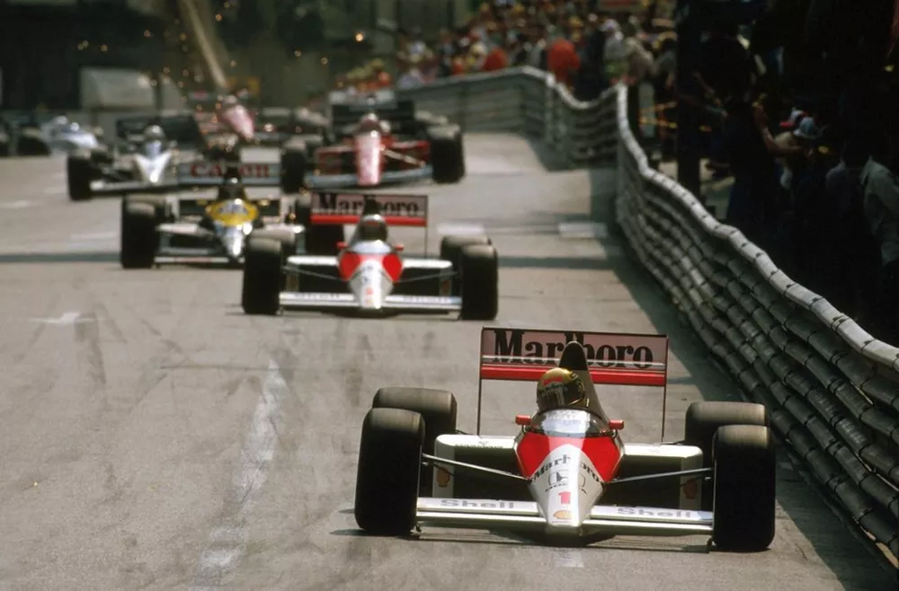 Primeira volta do GP de Mônaco de 1989 com Ayrton Senna liderando a McLaren pelas ruas de Monte Carlo